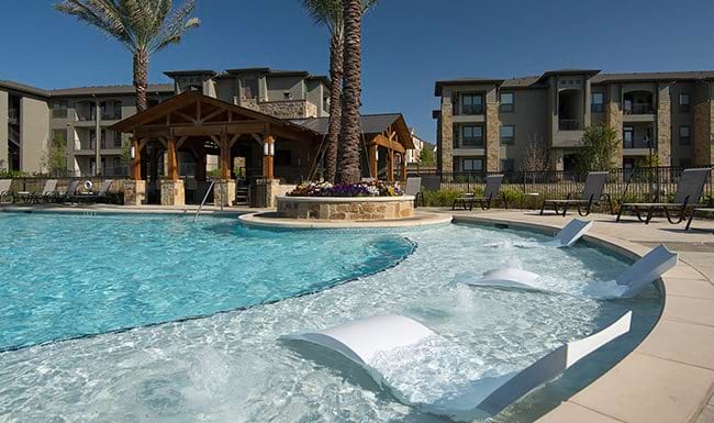 Resort-Style Pool pool with trees and lounge chairs